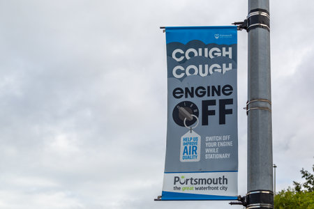 A sign on a lamppost promoting cleaner air with the slogan cough cough engine offの写真素材