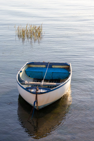 An old wooden boat moored in a calm marinaの写真素材