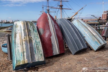 The Hulls of Four old wooden rowing boats stood up on a dock sideの写真素材