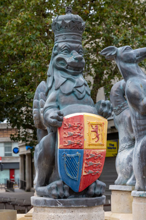 A lion statue wearing a crown and holding a coat of arms as part of the queens silver jubilee statue in Portsmouth city centreのeditorial素材