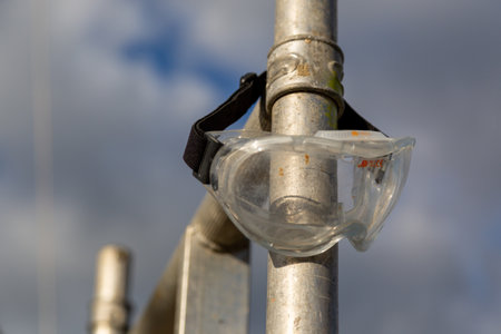 a pair of construction goggles left on a scaffolding poleの写真素材