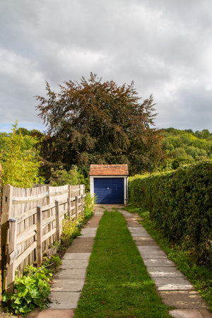a path leading to a car garage a part of a countryside homeの写真素材