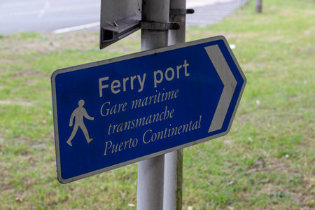 A sign on a lamppost pointing pedestrians to the ferry port in English, French and Spanishの写真素材