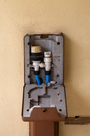 An open case that holds a water meter on the side of a houseの写真素材