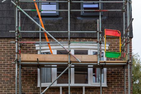 Scaffolding poles erected on the from of a house to enable construction or maintenance work to be carried outの写真素材