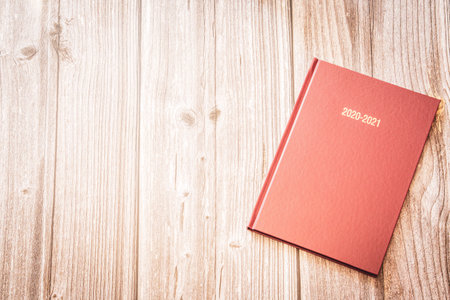 A 2020 and 2021 diary resting on a rustic wooden background with copy spaceの写真素材