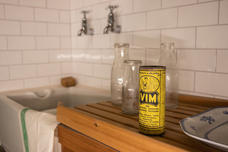 A scene from a 1960's kitchen with tiles, a butler sink, wooden draining board and Vim cleaning powderのeditorial素材