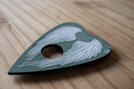 A close up of a pointer from an angel board used in much the same way as a ouija board to summon...