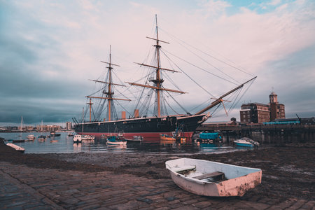 HMS Warrior moored in Portsmouth with an old fishing boat in the foregroundのeditorial素材