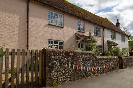 a typical english cottage with bunting hung outsideのeditorial素材