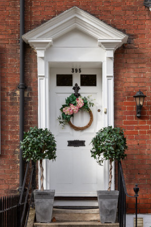 The front door of an English Victorian home with an autumn wreath hanging from the front doorのeditorial素材