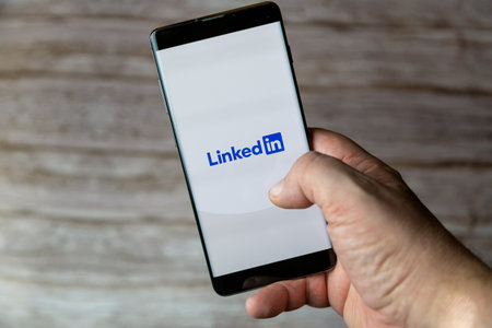 01-30-2021 Portsmouth, Hampshire, UK A hand holding a mobile phone or cell phone with the Linkedin app open on screenのeditorial素材