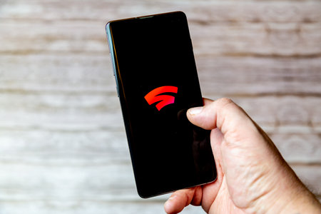 02-04-2021 Portsmouth, Hampshire, UK A handing holding a Mobile phone or cell phone with the Google stadia gaming app on screenのeditorial素材