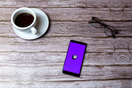 02-05-2021 Portsmouth, Hampshire, UK A mobile phone or cell phone laid on a wooden table or desk with the Twitch streaming app openのeditorial素材