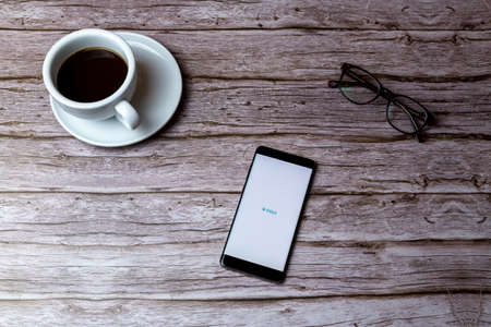 02-05-2021 Portsmouth, Hampshire, UK A mobile phone or cell phone laid on a wooden table or desk with the Fitbit app openのeditorial素材