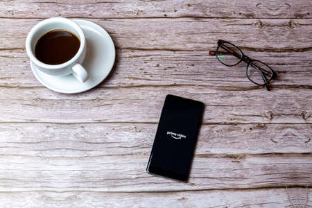02-05-2021 Portsmouth, Hampshire, UK A mobile phone or cell phone laid on a wooden table or desk with the Amazon Prime video app openのeditorial素材