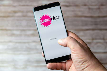 02-05-2021 Portsmouth, Hampshire, UK A Mobile phone or cell phone being held showing the Wowcher app open on screenのeditorial素材