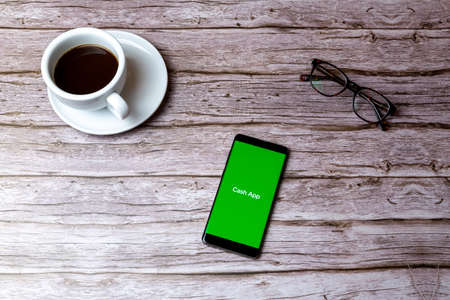 02-05-2021 Portsmouth, Hampshire, UK A mobile phone or cell phone laid on a wooden table or desk with the cash app app openのeditorial素材