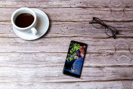 02-05-2021 Portsmouth, Hampshire, UK A mobile phone or cell phone laid on a wooden table or desk with the Tesco Clubcard app openのeditorial素材