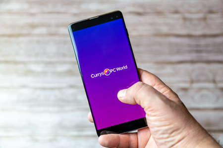 02-05-2021 Portsmouth, Hampshire, UK A Mobile phone or cell phone being held showing the Currys PC world app open on screenのeditorial素材