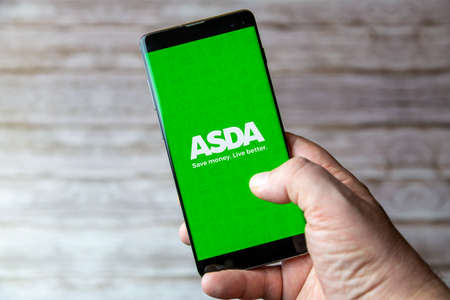 02-05-2021 Portsmouth, Hampshire, UK A Mobile phone or cell phone being held showing the ASDA shopping app open on screenのeditorial素材