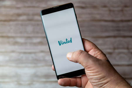 02-05-2021 Portsmouth, Hampshire, UK A Mobile phone or cell phone being held showing the Vinted app open on screenのeditorial素材