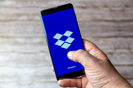 02-05-2021 Portsmouth, Hampshire, UK A Mobile phone or cell phone being held showing the Dropbox app open on screenのeditorial素材