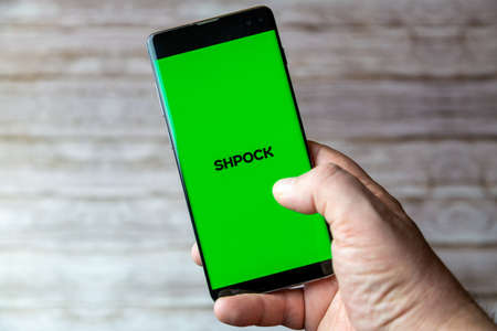 02-05-2021 Portsmouth, Hampshire, UK A Mobile phone or cell phone being held showing the Shpock app open on screenのeditorial素材