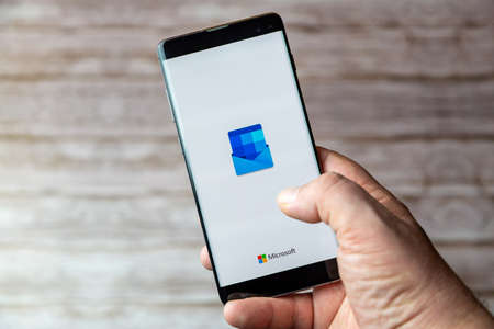 02-05-2021 Portsmouth, Hampshire, UK A Mobile phone or cell phone being held showing the Microsoft Outlook app open on screenのeditorial素材