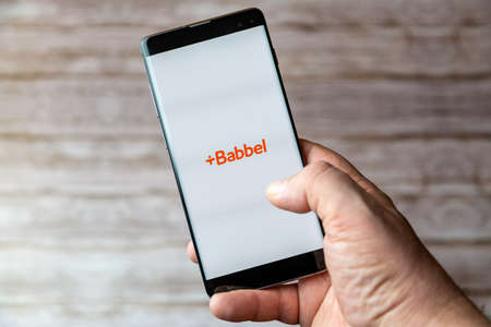 02-05-2021 Portsmouth, Hampshire, UK A Mobile phone or cell phone being held showing the Babbel app open on screenのeditorial素材