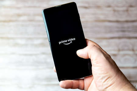 02-05-2021 Portsmouth, Hampshire, UK A Mobile phone or cell phone being held showing the Amazon Prime video app open on screenのeditorial素材