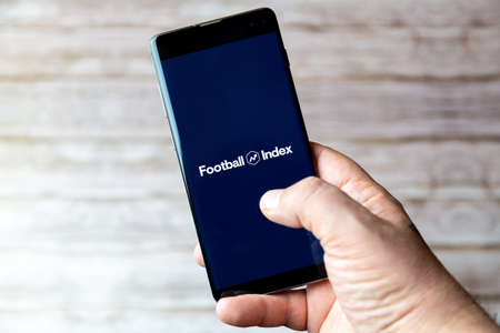 02-05-2021 Portsmouth, Hampshire, UK A Mobile phone or cell phone being held showing the football Index trading app open on screenのeditorial素材