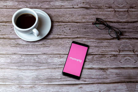 02-05-2021 Portsmouth, Hampshire, UK A mobile phone or cell phone laid on a wooden table or desk with the app openのeditorial素材