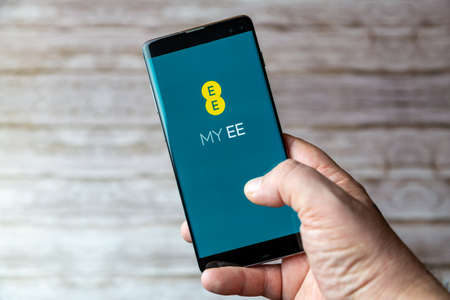 02-05-2021 Portsmouth, Hampshire, UK A Mobile phone or cell phone being held showing the EE Mobile app open on screenのeditorial素材