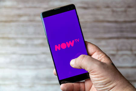 02-05-2021 Portsmouth, Hampshire, UK A Mobile phone or cell phone being held showing the Now TV app open on screenのeditorial素材