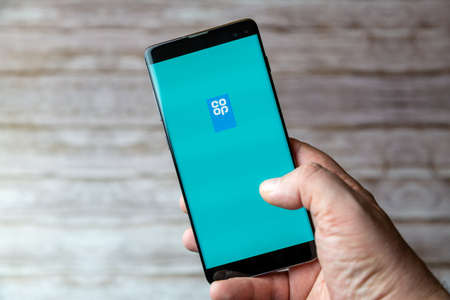 02-05-2021 Portsmouth, Hampshire, UK A Mobile phone or cell phone being held showing the Co-Op app open on screenのeditorial素材