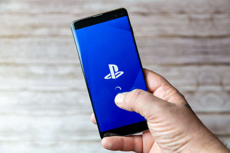 02-05-2021 Portsmouth, Hampshire, UK A Mobile phone or cell phone being held showing the Playstation mobile app open on screenのeditorial素材