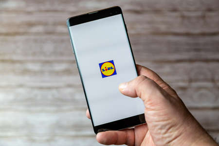 02-05-2021 Portsmouth, Hampshire, UK A Mobile phone or cell phone being held showing the Lidl Shopping app open on screenのeditorial素材