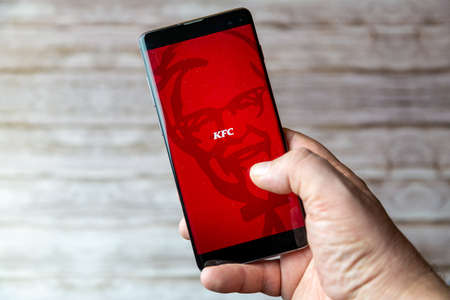 02-05-2021 Portsmouth, Hampshire, UK A Mobile phone or cell phone being held showing the KFC app open on screenのeditorial素材