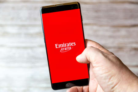 02-08-2021 Portsmouth, Hampshire, UK A mobile phone or cell phone being held in a hand with the Emirates Fly better app open on screenのeditorial素材