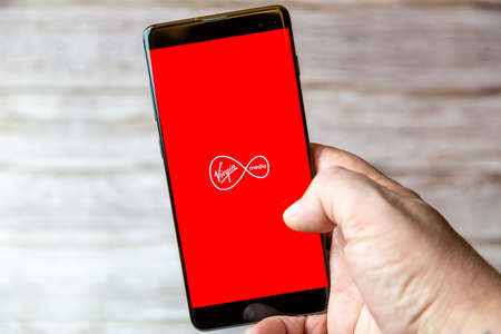 02-08-2021 Portsmouth, Hampshire, UK A mobile phone or cell phone being held in a hand with the Virgin Media app open on screenのeditorial素材