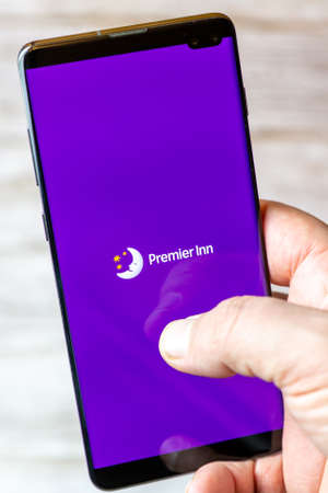 02-08-2021 Portsmouth, Hampshire, UK A mobile phone or cell phone being held in a hand with the Premier Inn Hotel app open on screenのeditorial素材