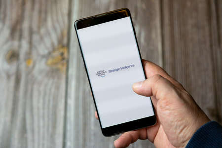02-10-2021 Portsmouth, hampshire, UK A mobile phone or cell phone being held by a hand with the World economic forum app open on screenのeditorial素材