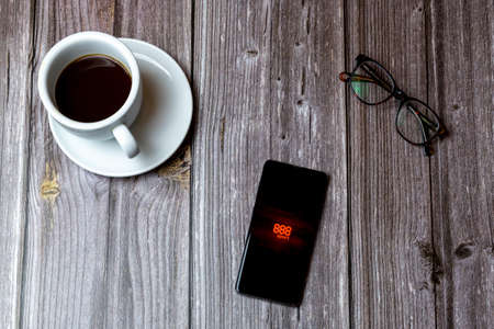 02/10/2021 Portsmouth, Hampshire, UK A mobile phone or cell phone laid on a wooden table with the 888 Betting app open on screen next to a coffeeのeditorial素材