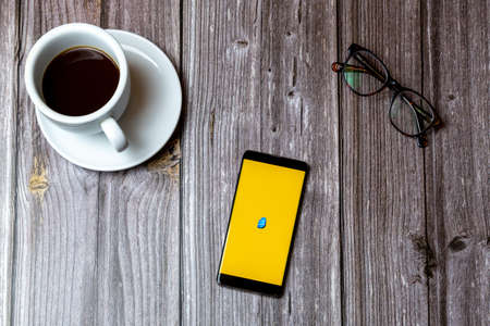 02/10/2021 Portsmouth, Hampshire, UK A mobile phone or cell phone laid on a wooden table with the Rosetta stone app open on screen next to a coffeeのeditorial素材