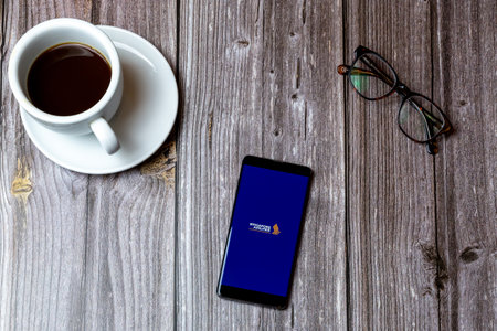 02/10/2021 Portsmouth, Hampshire, UK A mobile phone or cell phone laid on a wooden table with the Singapore airlines app open on screenのeditorial素材