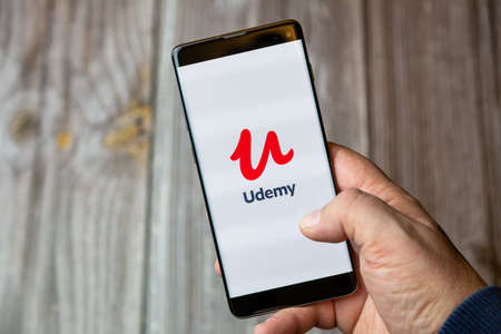 02-10-2021 Portsmouth, hampshire, UK A mobile phone or cell phone being held by a hand with the Udemy app open on screenのeditorial素材