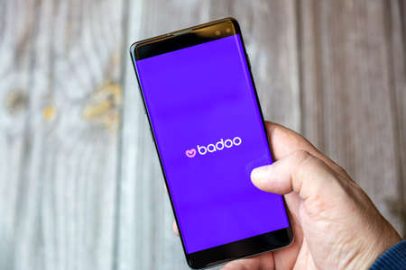 02-10-2021 Portsmouth, hampshire, UK A mobile phone or cell phone being held by a hand with the badoo online dating app open on screenのeditorial素材