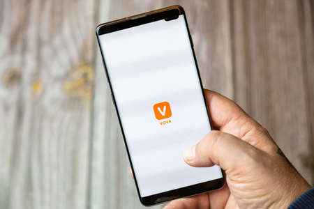 02-10-2021 Portsmouth, hampshire, UK A mobile phone or cell phone being held by a hand with the VOVA app open on screenのeditorial素材