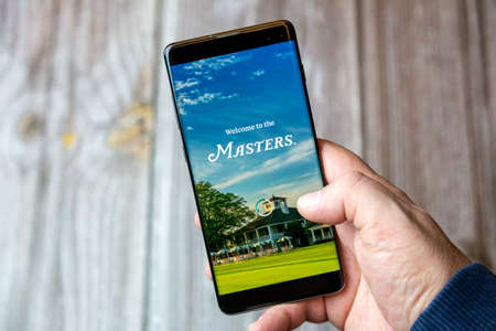 02-10-2021 Portsmouth, hampshire, UK A mobile phone or cell phone being held by a hand with the Masters Golf app open on screenのeditorial素材
